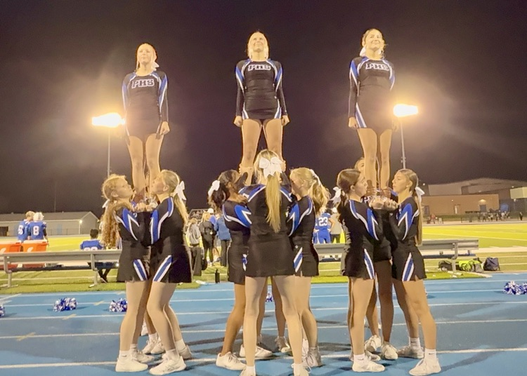 picture of jv cheerleaders doing a stunt during a football game