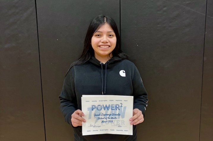 femlae student with long dark brown/black hair accepting her student of the month certificate