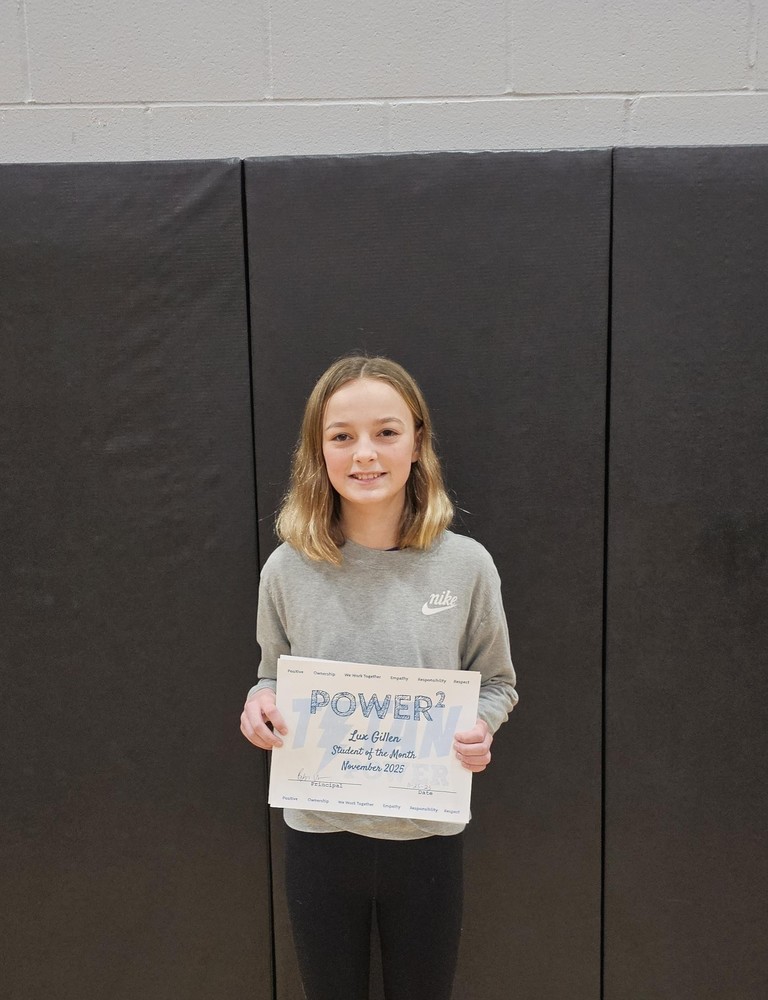 female student with medium brown hair, gray sweatshirt and black pants