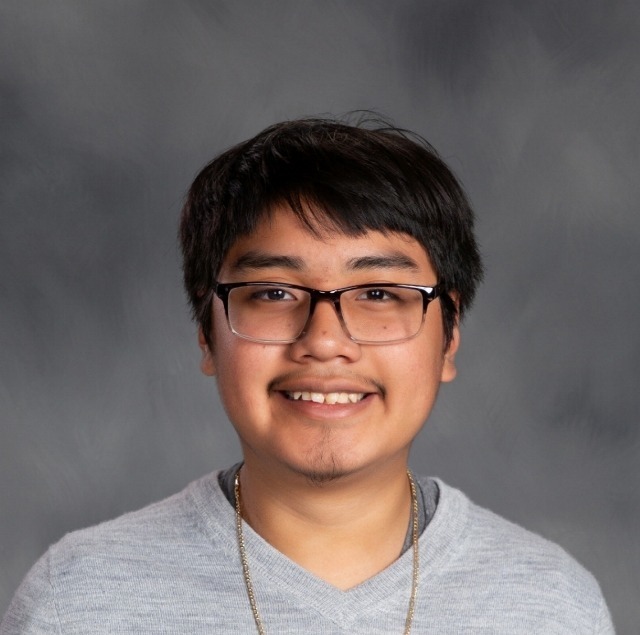 male student with dark brown hair, glasses and a grey tshirt