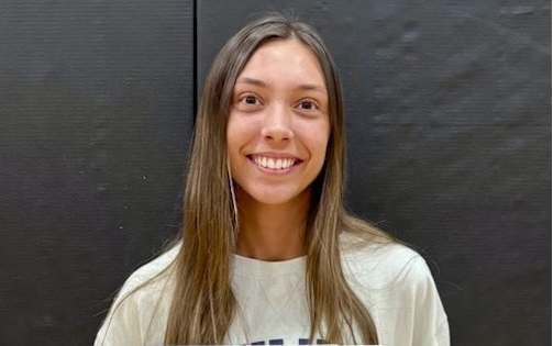 female student with long brown hair receiving student of the month certificate
