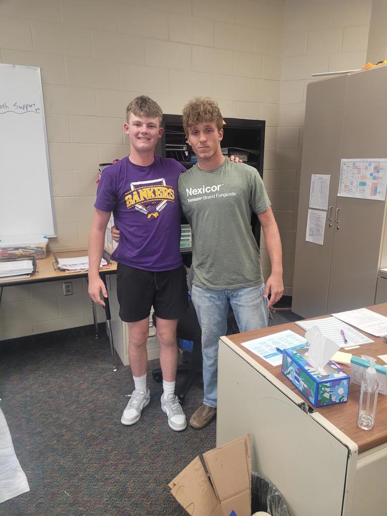 two male  students pretending they are working on float prep