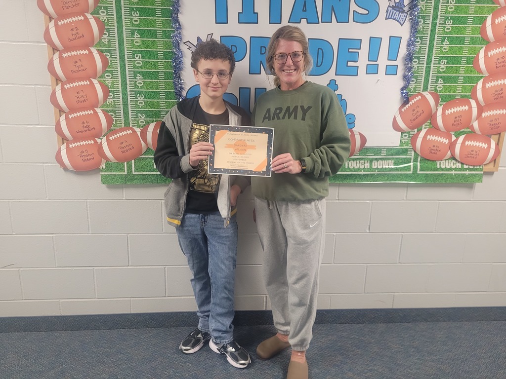 male student being recognized by a school board member