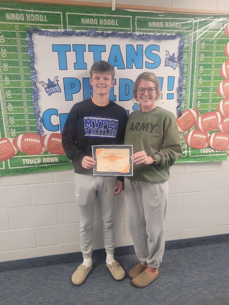 male student receiving recognition from a school board member for student of the month