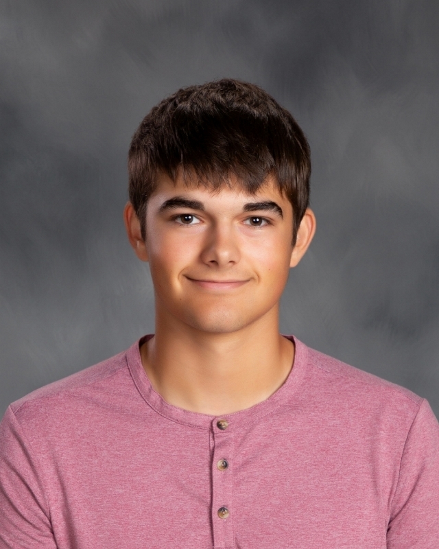 male student with brown hair and eyes and a heathered red shirt