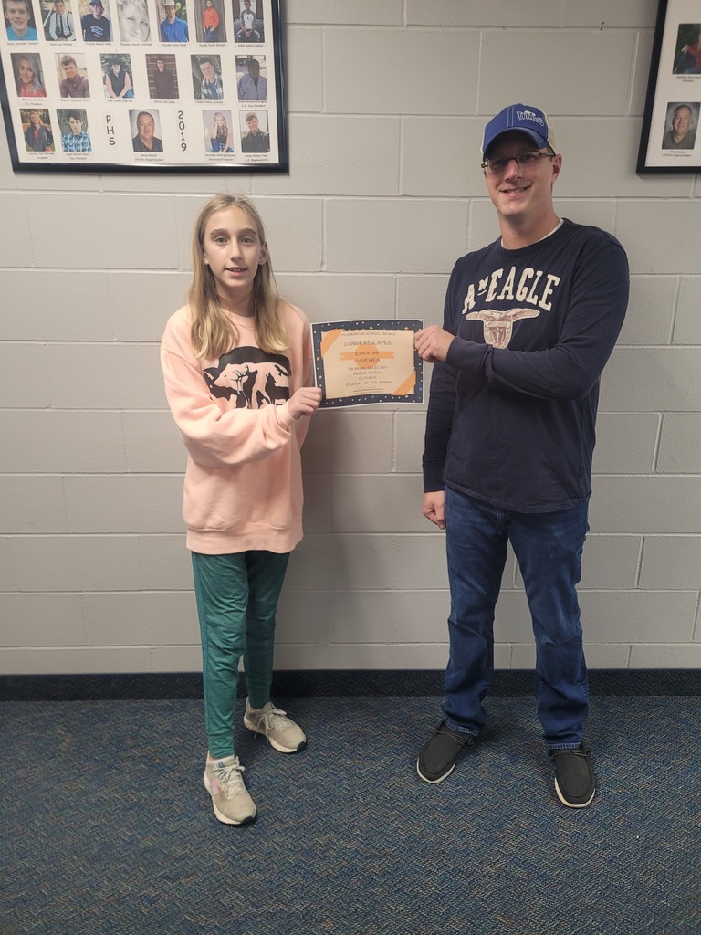 female student being recognized by one of the school board members for Student of the Month