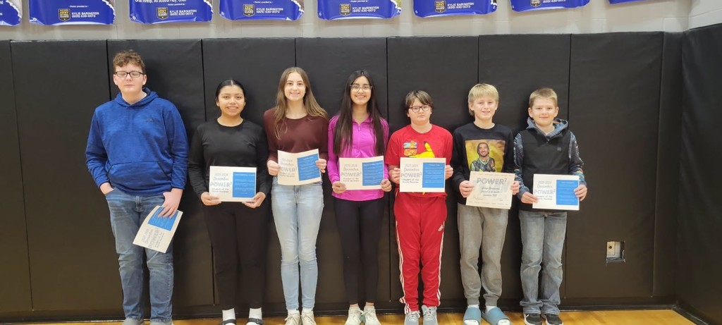 several students of middle school age receiving certificates for being nominated student of the month for December