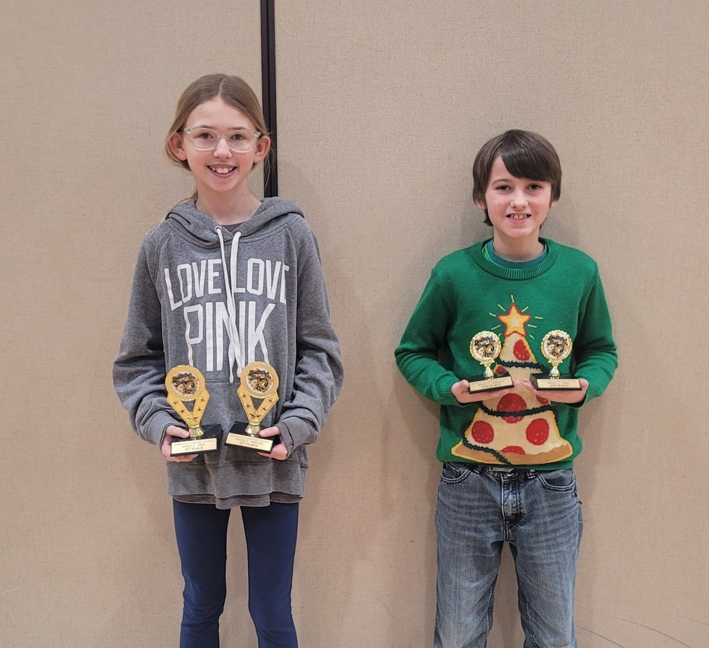 two fifth grade students posing with their spelling bee trophies