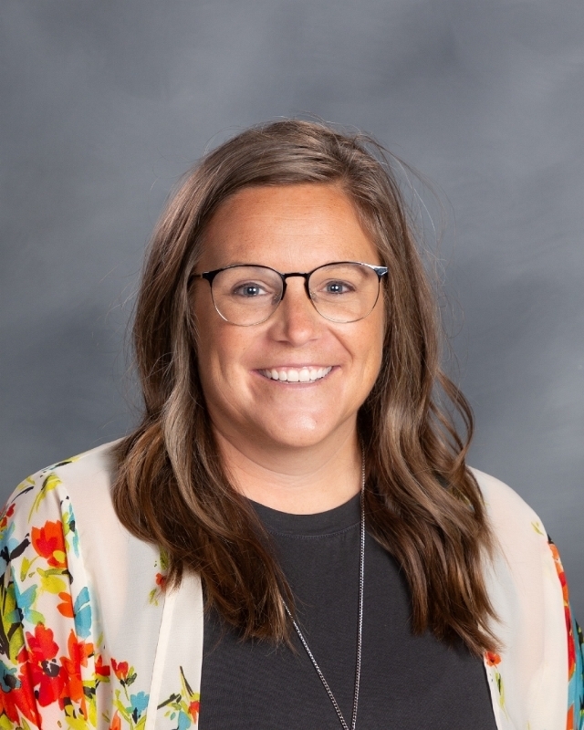 female teacher with long brown hair and glasses