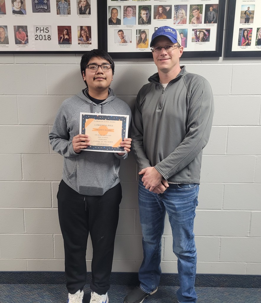 one male student being recognized for student of the month by one male adult school board member