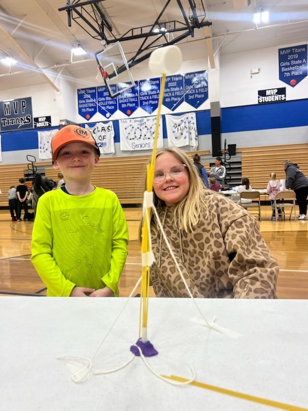 two students creating a marshmallow tower at family fun night