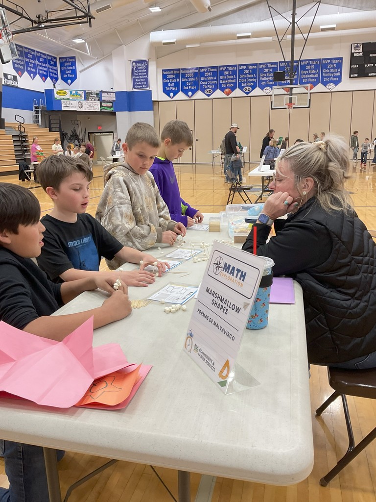 a group of students and a staff member creating creating marshmallow shapes