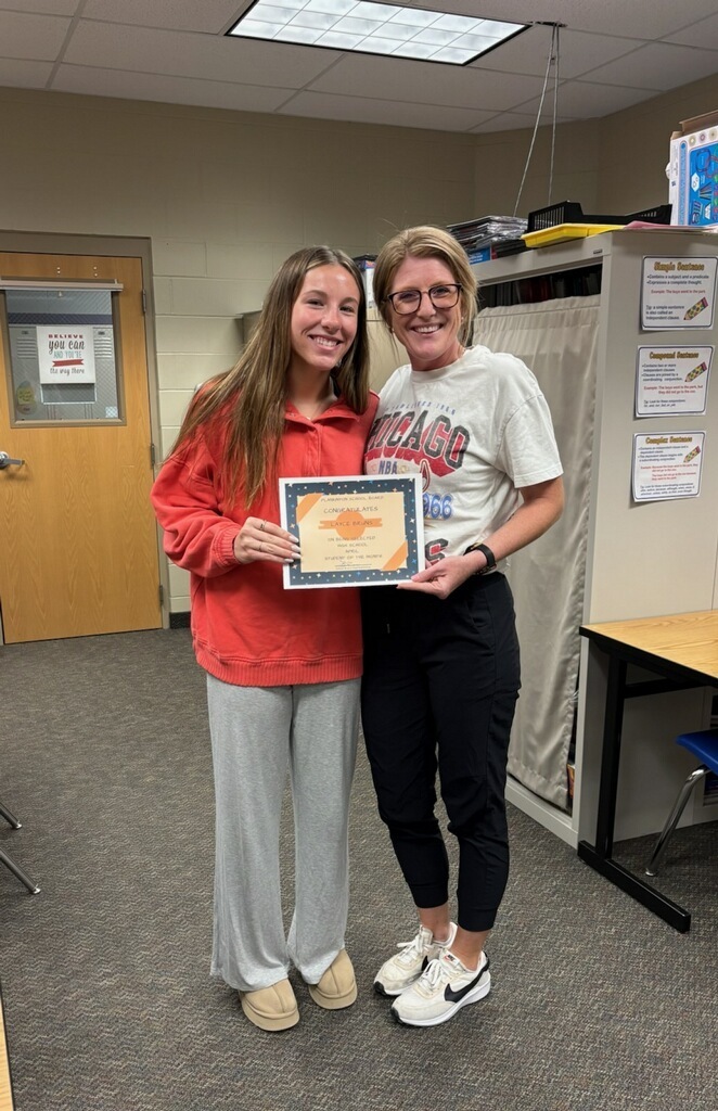school board member congratulating high school student of the month for April