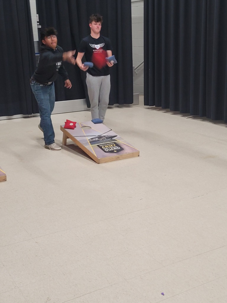 students playing corn hole on the stage