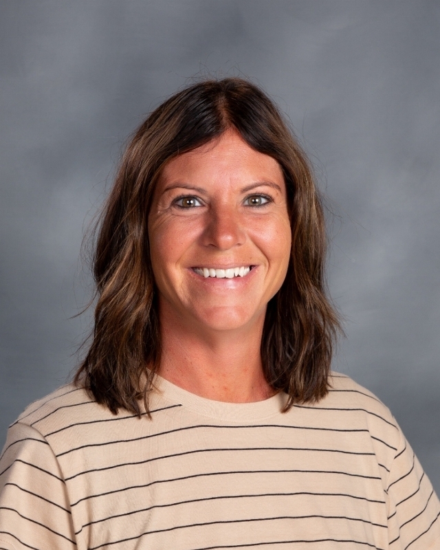 female with short dark brown hair and a tan striped shirt