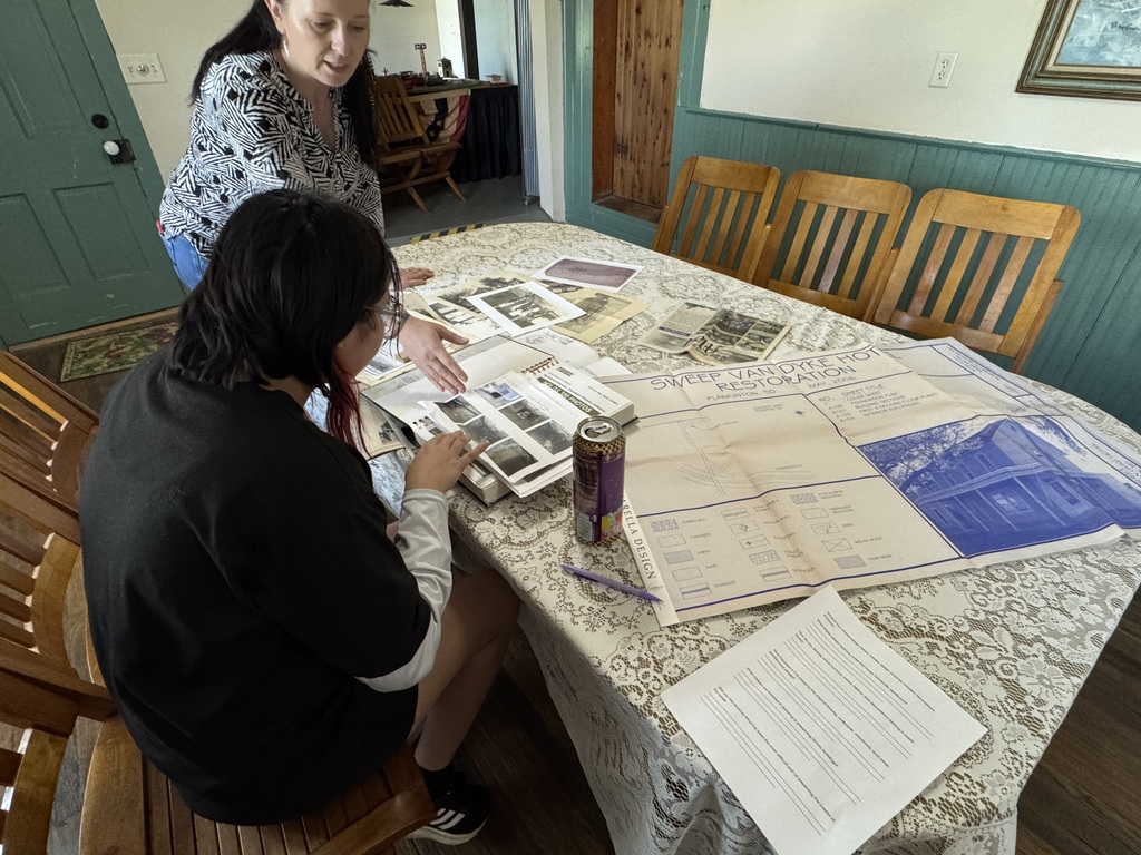 Magdalena Popek-Hurst showing old pictures of how the building used to look. She also showed old pieces of wallpaper and parts of the wall.