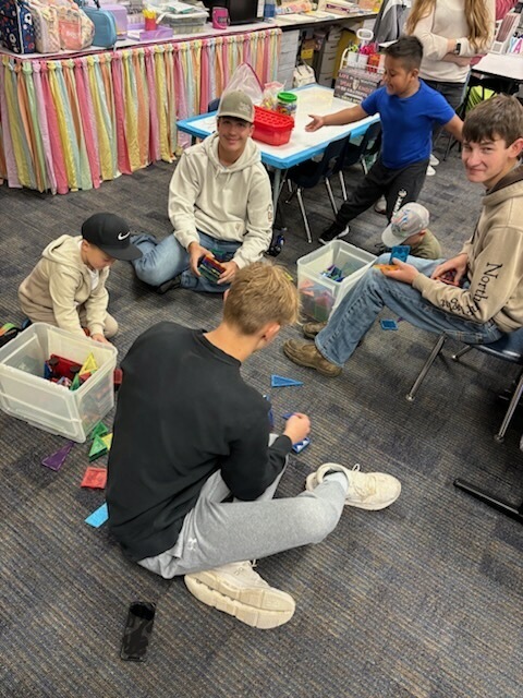 older students being buddies with younger students for a homecoming activity