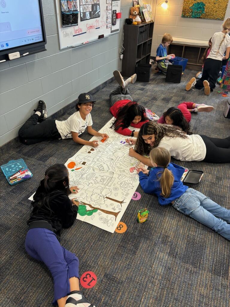 older students working with younger students during a homecoming activity