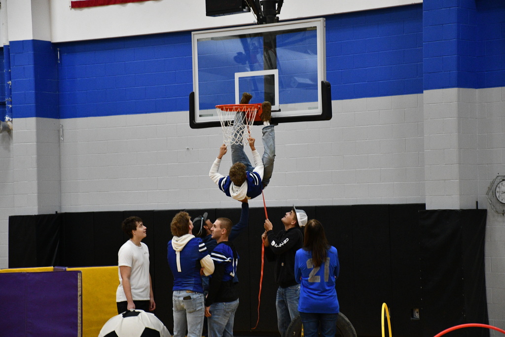 Paxton Nedved climbing the hoop to tie the tire to it. 