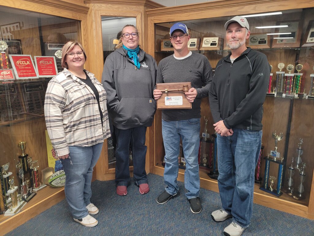 four school board members posing with an award that they earned