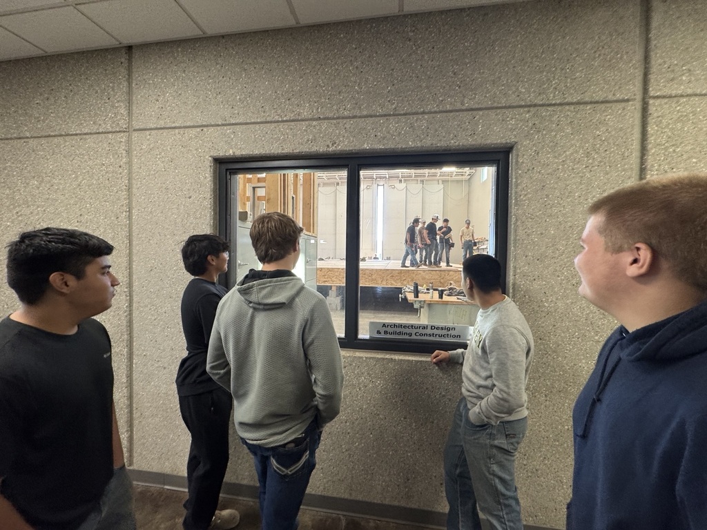 Students looking at the one program building a house