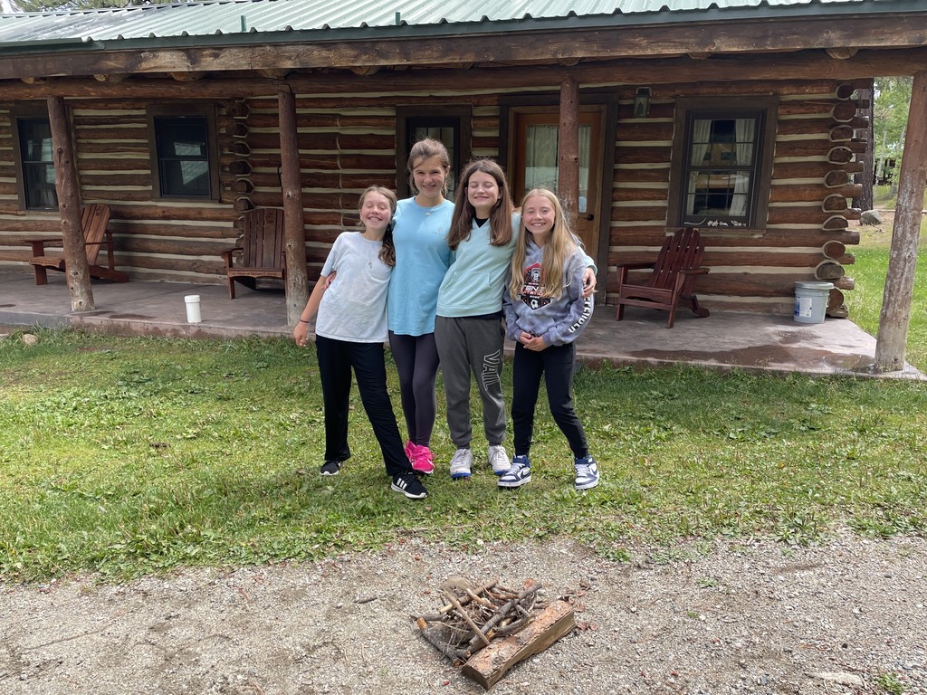 4 girls outside their cabin