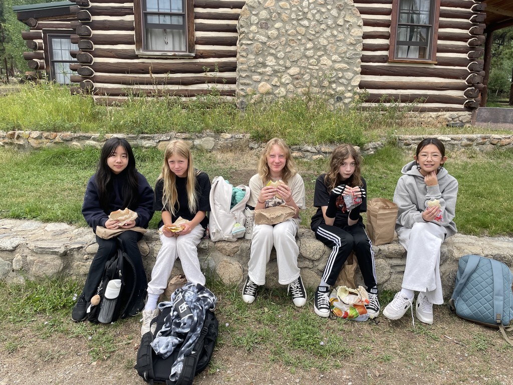5 girls eating lunch outside cabin
