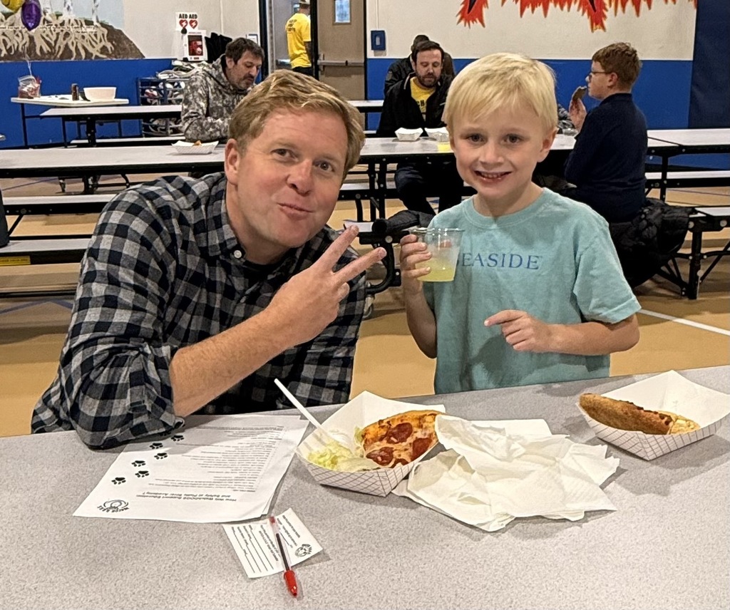 dad and son enjoying pizza at watch dog night