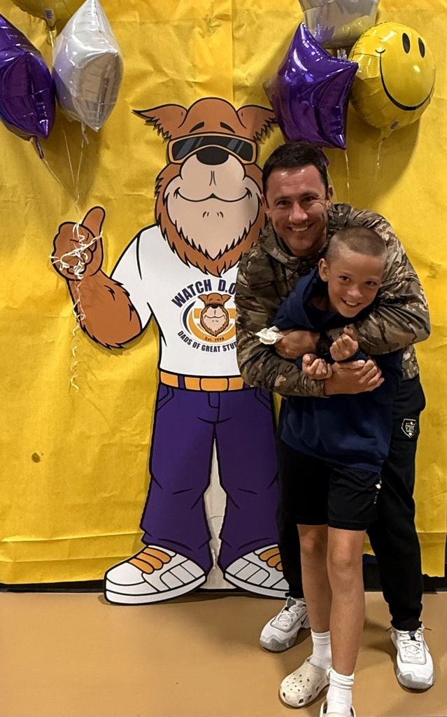 dad hugging son with ballloons at watch dog event