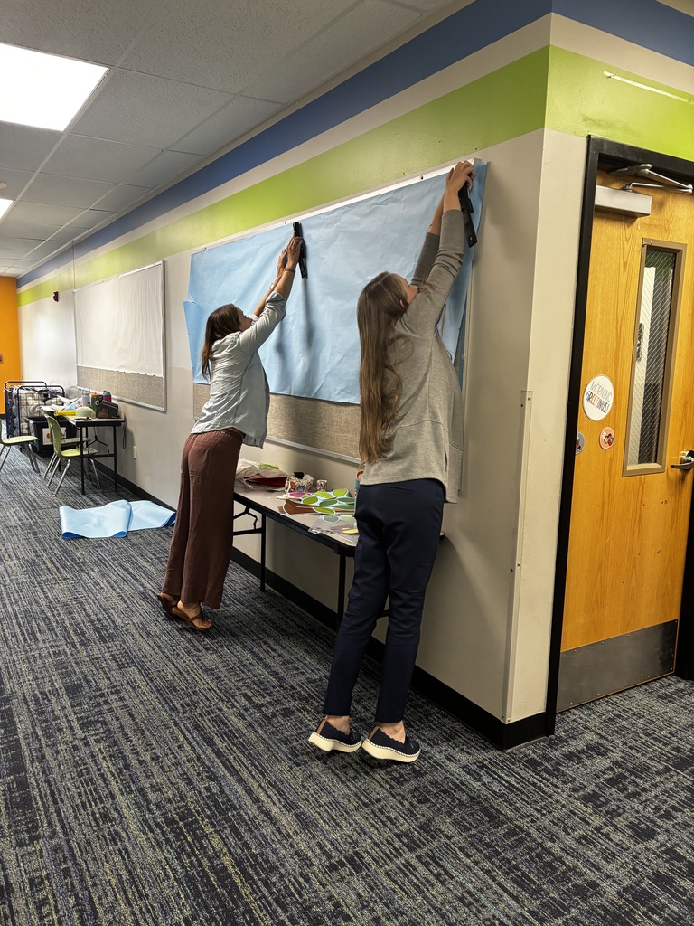 Putting up a bulletin board in the hallway