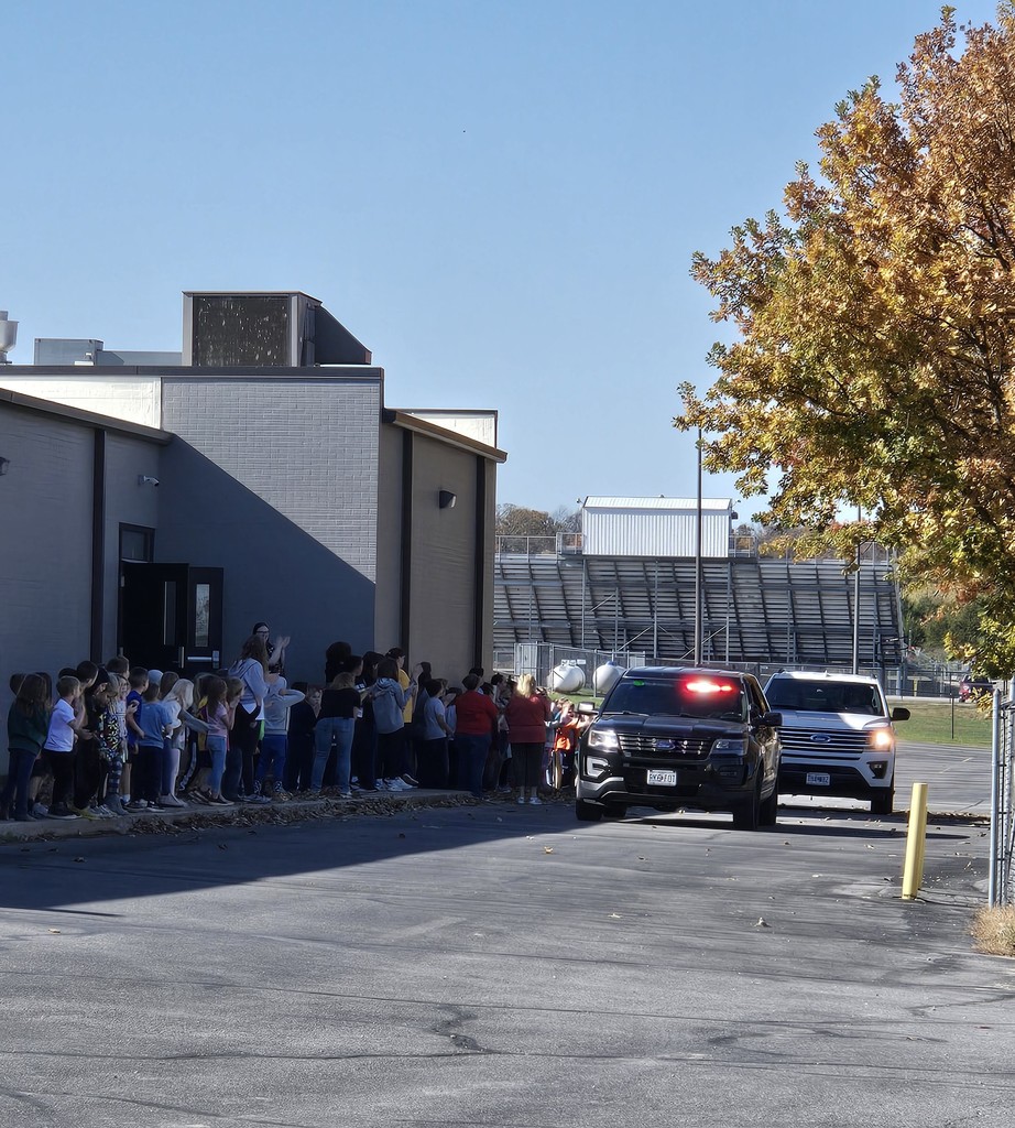 Knox in the Expedition with a police escort driving by the Elementary students that wishing her good luck.