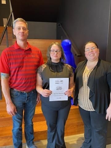 Student poses with certificate. 