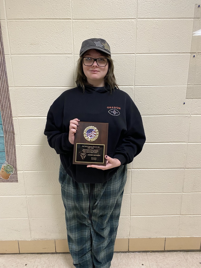 Student poses with plaque.