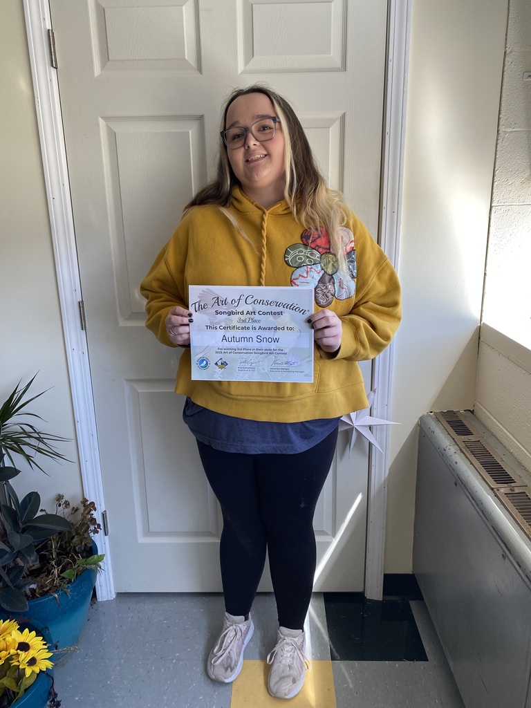 Student holds certificate.