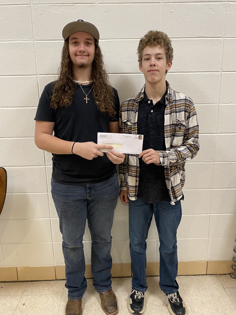 Students hold check.