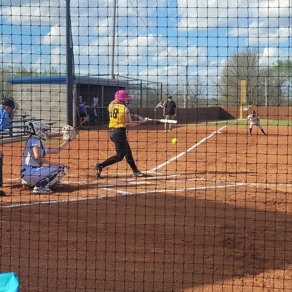 softball player hitting the ball