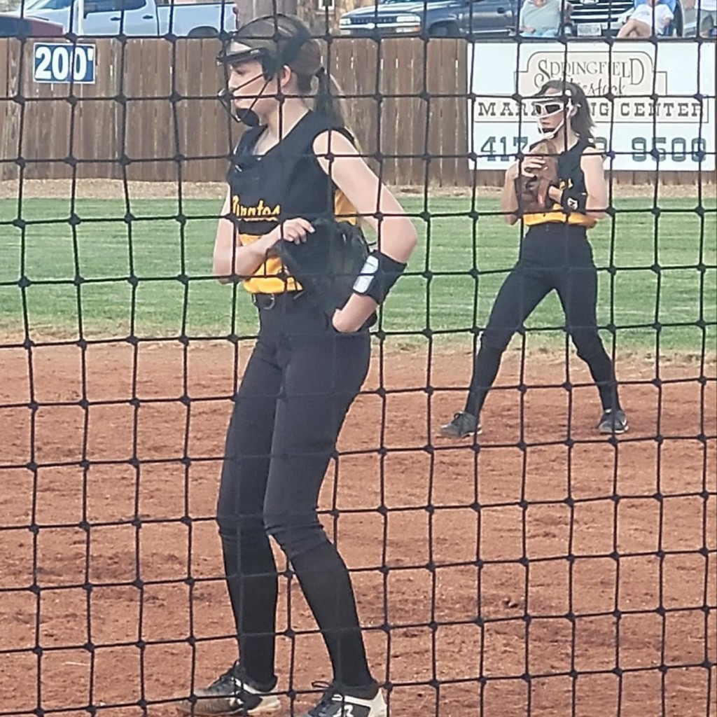two softball players on the infield 