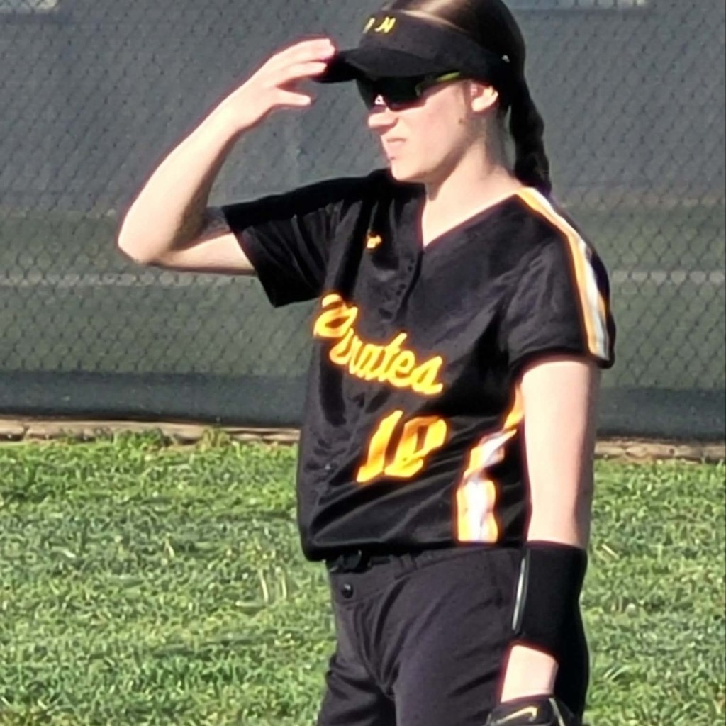 softball outfielder shielding her eyes from the sun