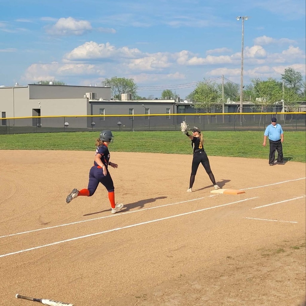 softball player getting the out at 1st base