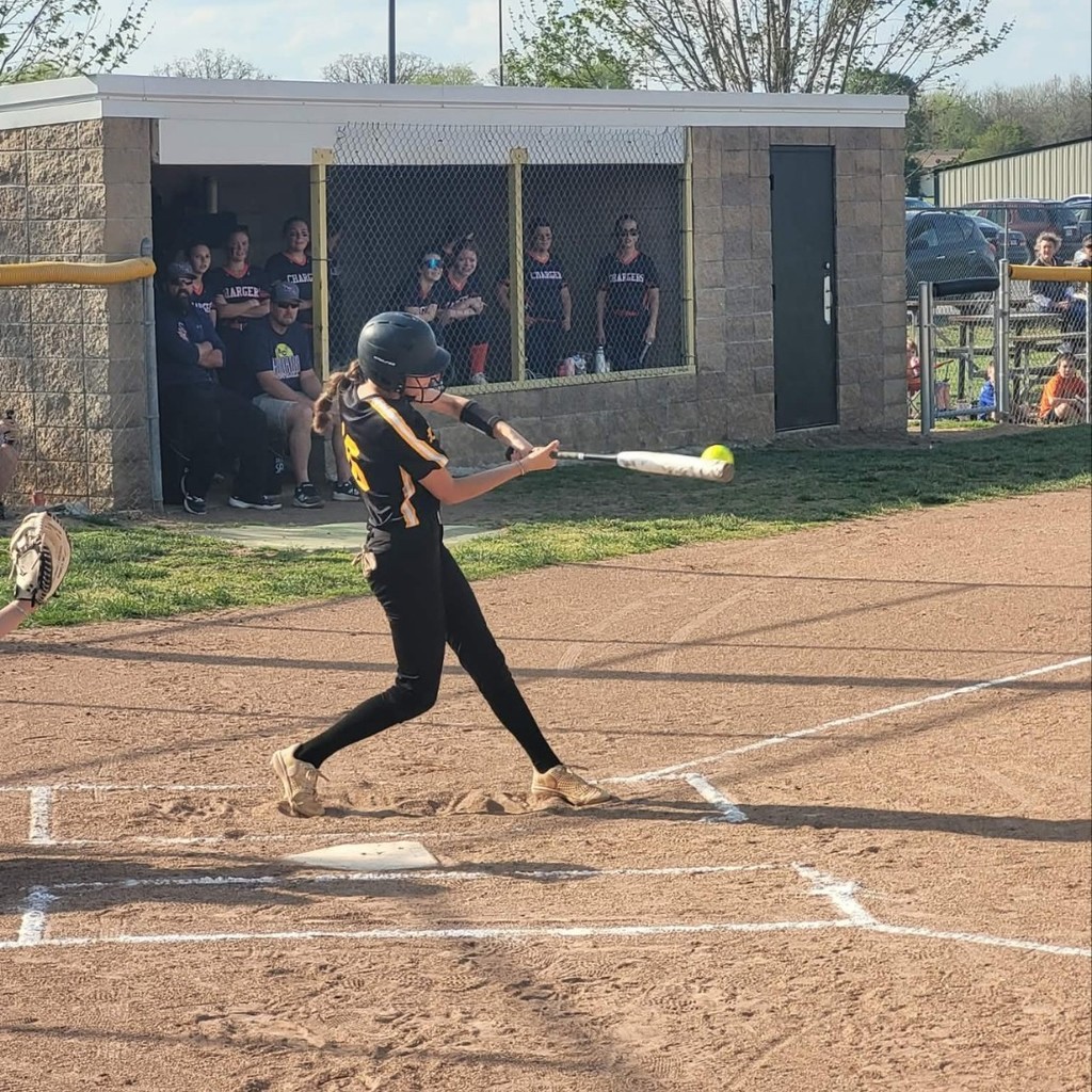 softball player hitting the ball 
