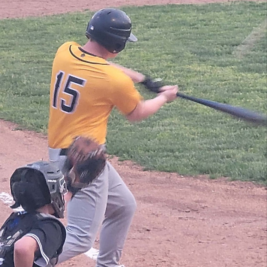 baseball player swinging at the pitch