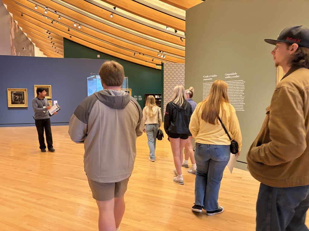 Students look at art gallery. 