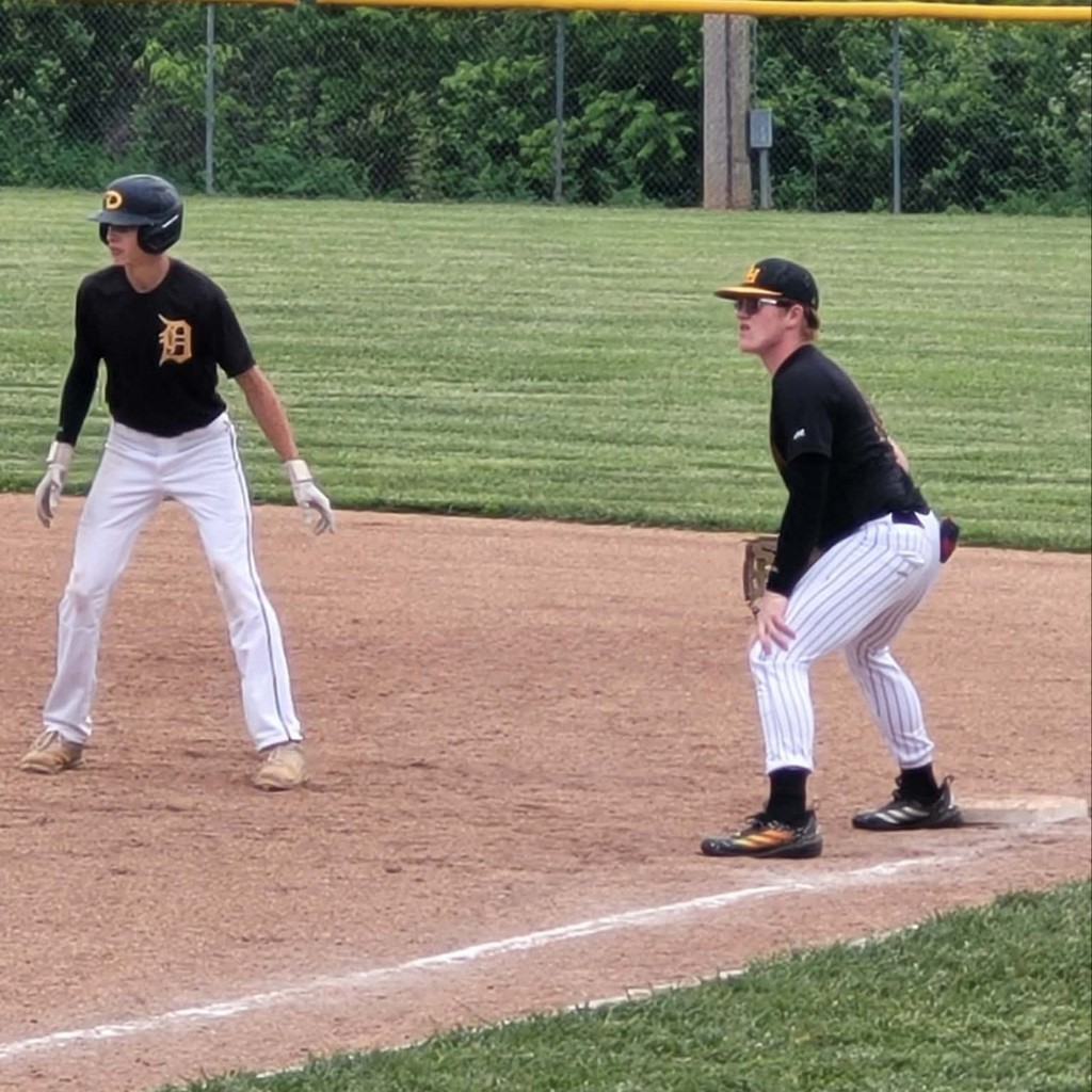 hs baseball player at 1st base with a runner taking a leadoff