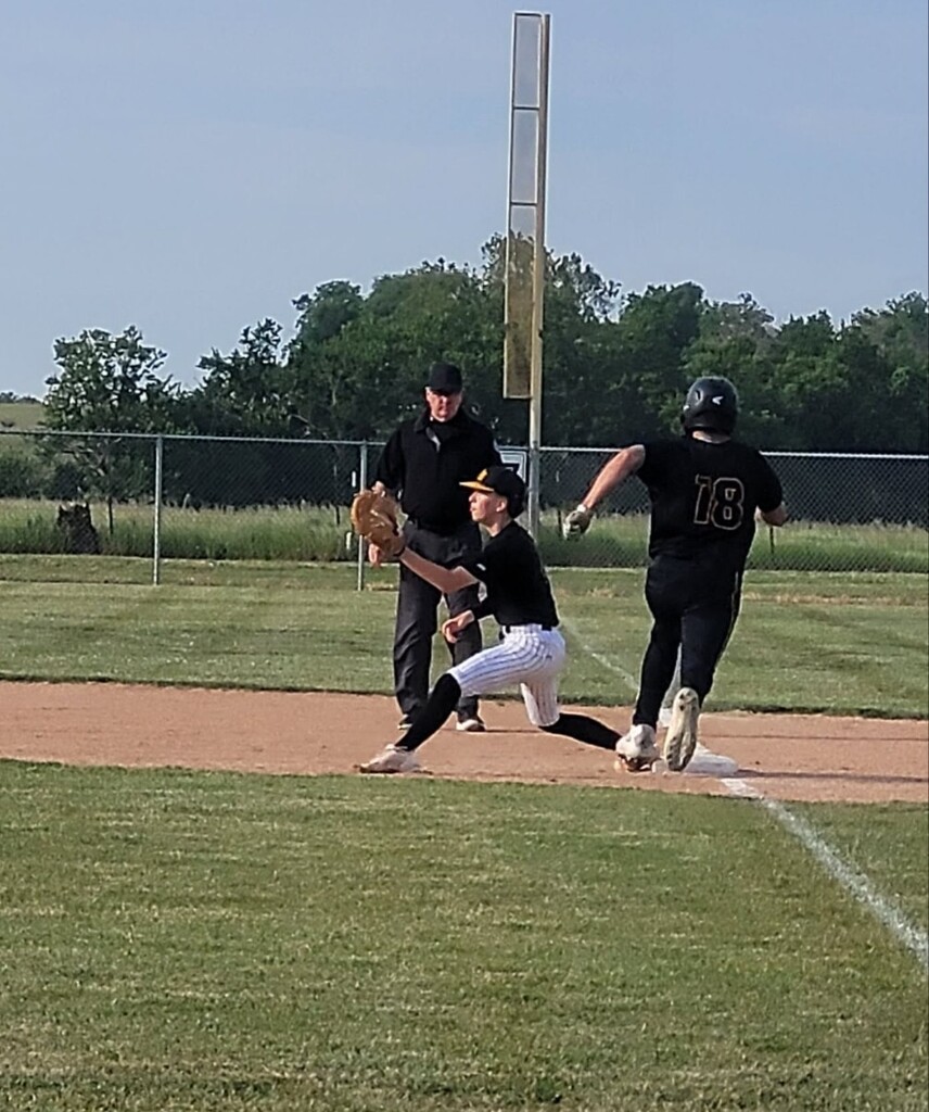 hs baseball player running to 1st base and the 1st baseman waiting on the ball