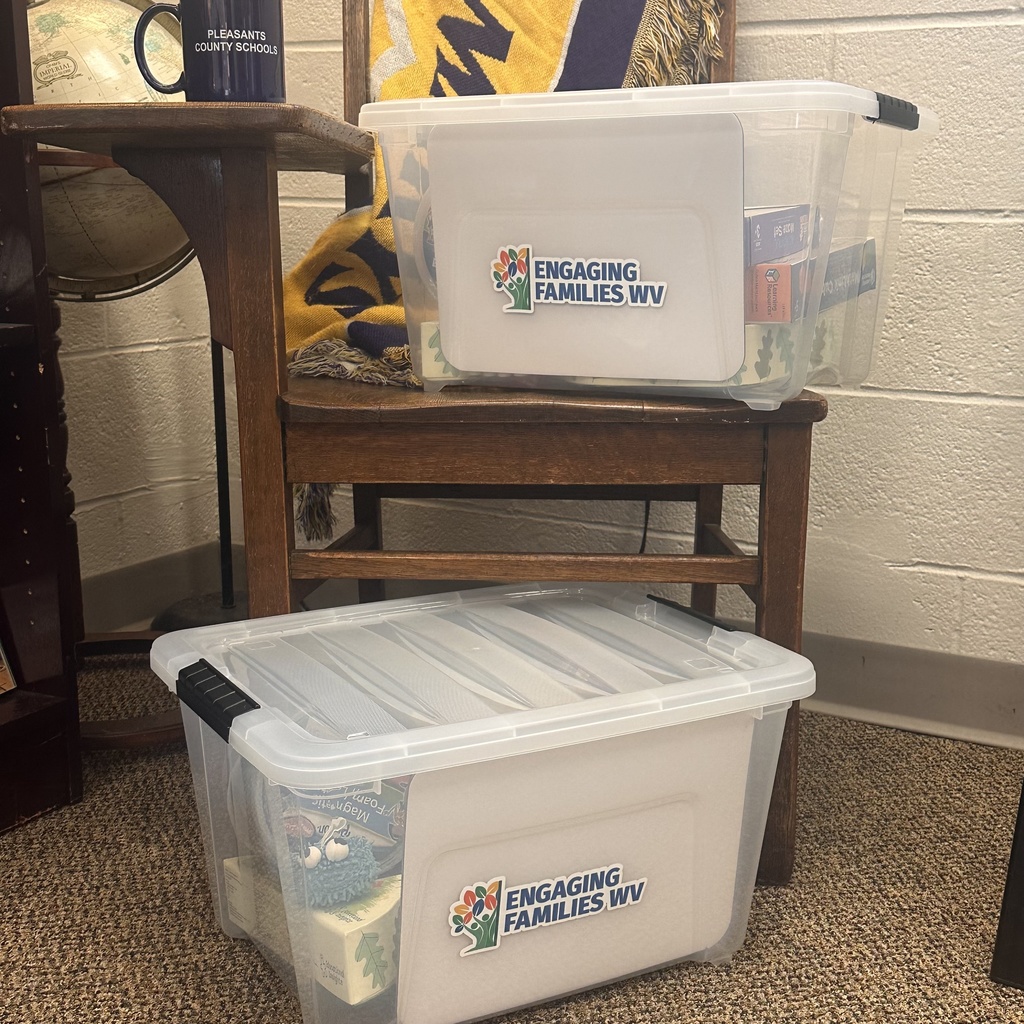 Picture of two totes with family activities in them sitting on an old fashioned school desk.