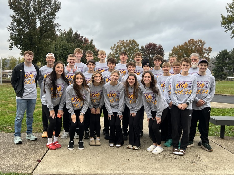 a group of student athletes in gray shirts and their coaches 