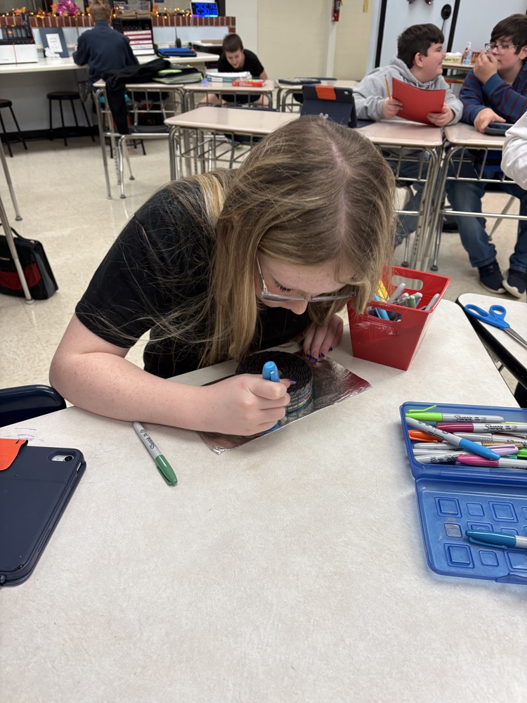Students in Mrs. Kincaid’s class stand in a classroom holding homemade Mylar-style balloons shaped and decorated for Thanksgiving. 