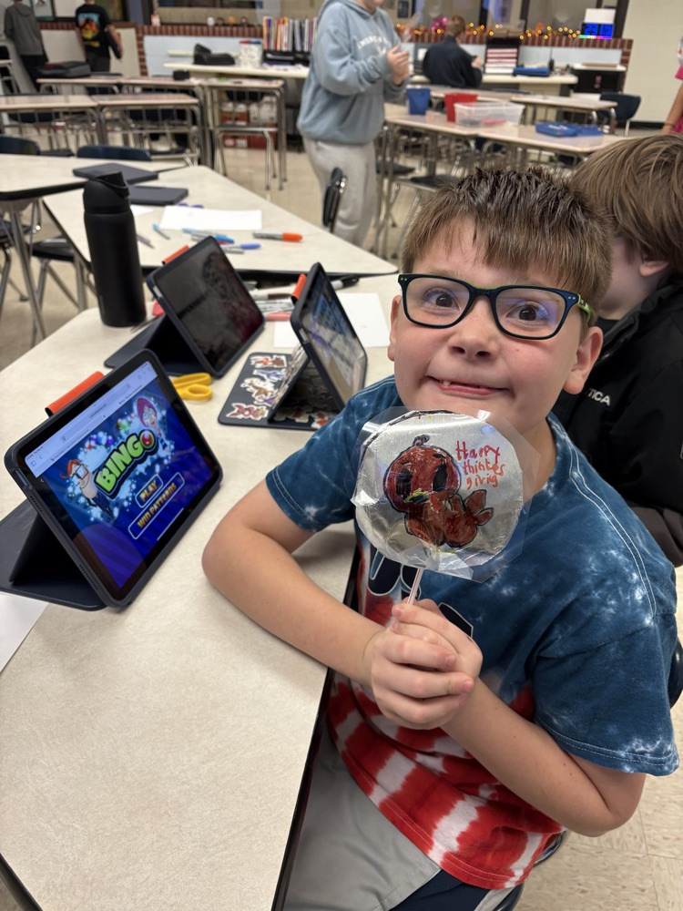 Students in Mrs. Kincaid’s class stand in a classroom holding homemade Mylar-style balloons shaped and decorated for Thanksgiving. 