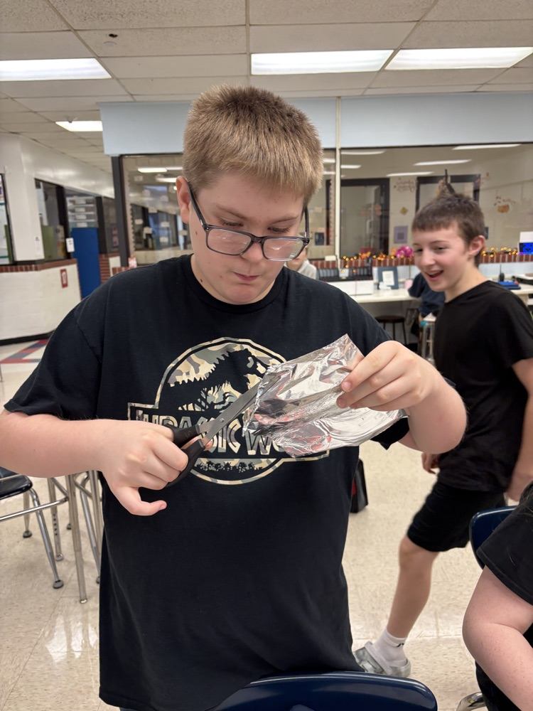 Students in Mrs. Kincaid’s class stand in a classroom holding homemade Mylar-style balloons shaped and decorated for Thanksgiving. 