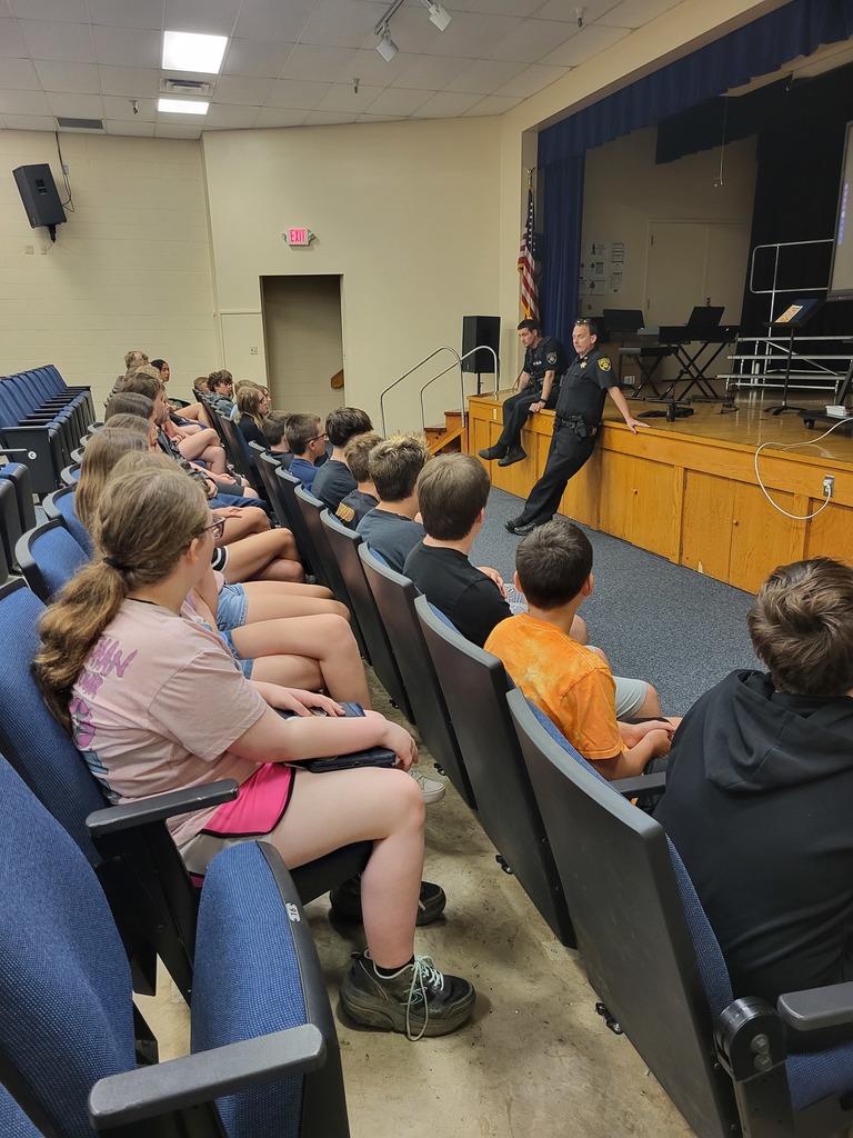 A Pleasants County Sheriff’s Department officer speaking to middle school students in a classroom about drug awareness, with students seated and listening attentively